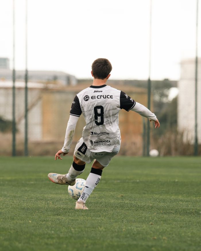 services-01 Rear view of a soccer player in action on a green field, showcasing dynamic movement.