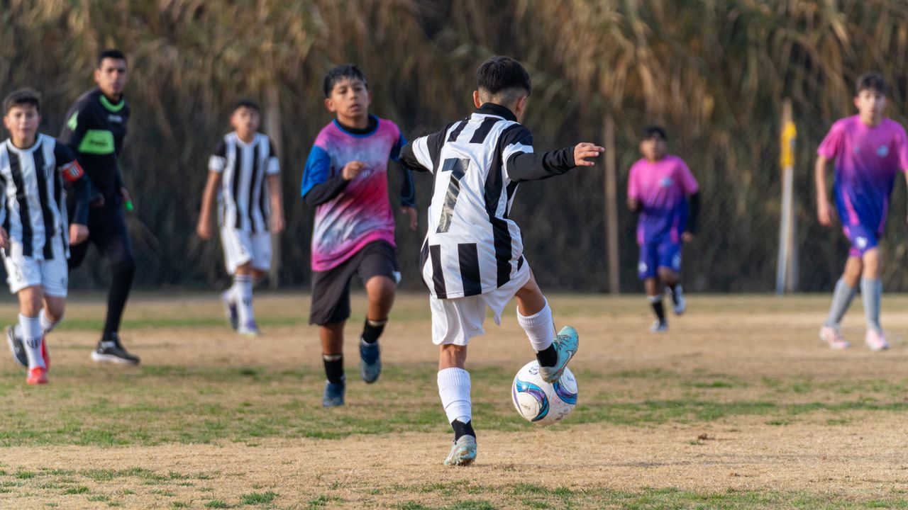 Boys playing soccer in a lively outdoor match showing agility and teamwork.